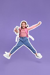 Happy school child with backpack jumping on violet background