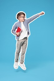 School child in glasses holding book and jumping on light blue background