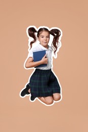 School child holding book and jumping on dark beige background