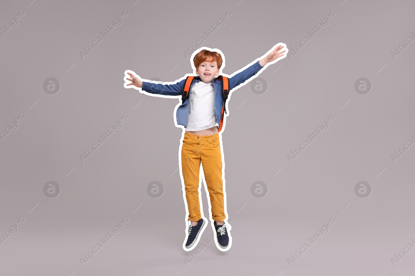 Image of Happy school child with backpack jumping on grey background