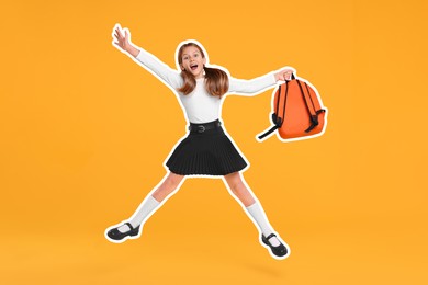 Happy school child with backpack jumping on orange background