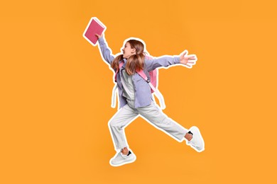 Happy school child with book and backpack jumping on orange background