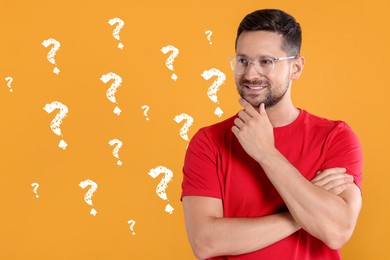 Image of Smiling man thinking about something on orange background. Question marks near him