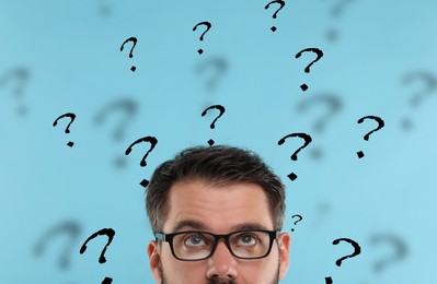 Image of Man and question marks on light blue background, closeup