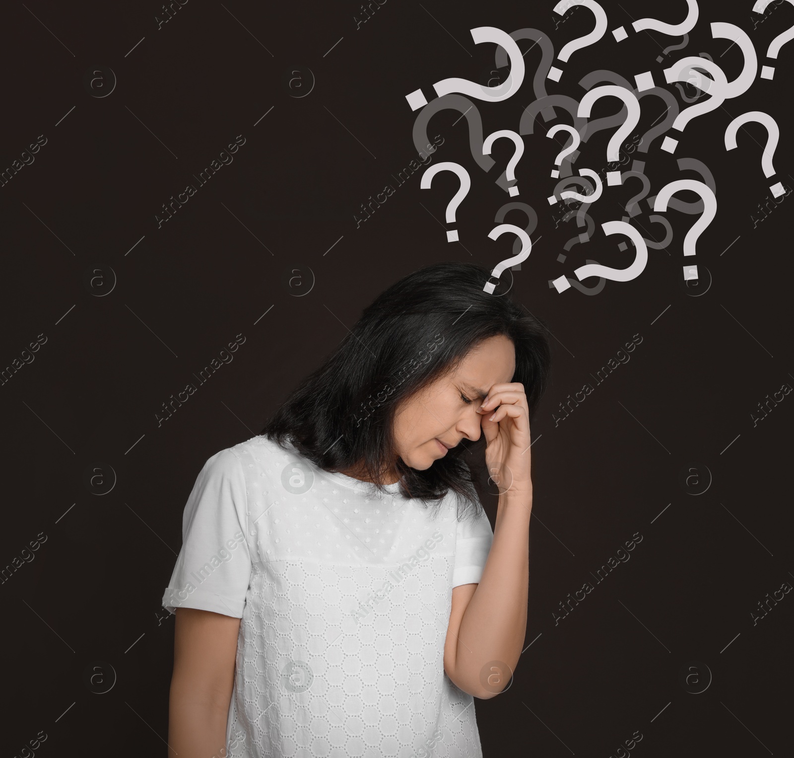 Image of Woman suffering from amnesia on dark brown background. Question marks flying out of her head