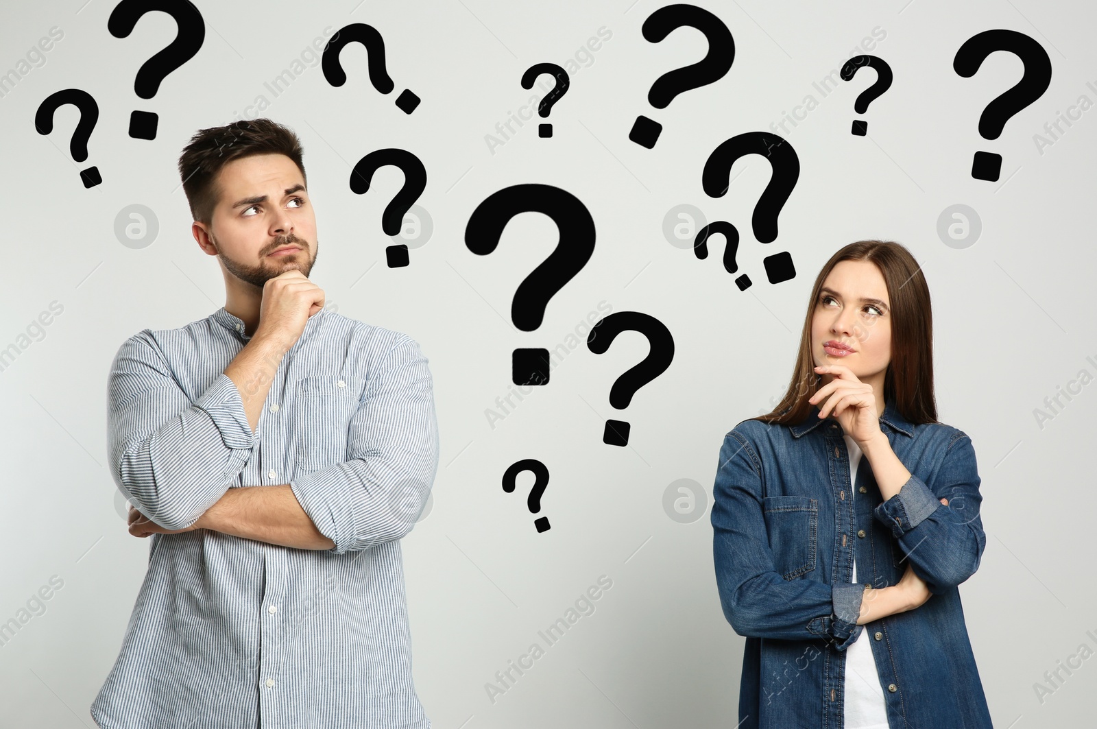 Image of Puzzled man and woman on light background. Question marks around them