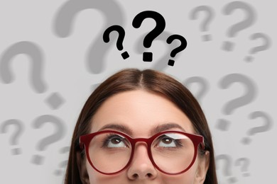 Image of Woman and question marks on light background, closeup