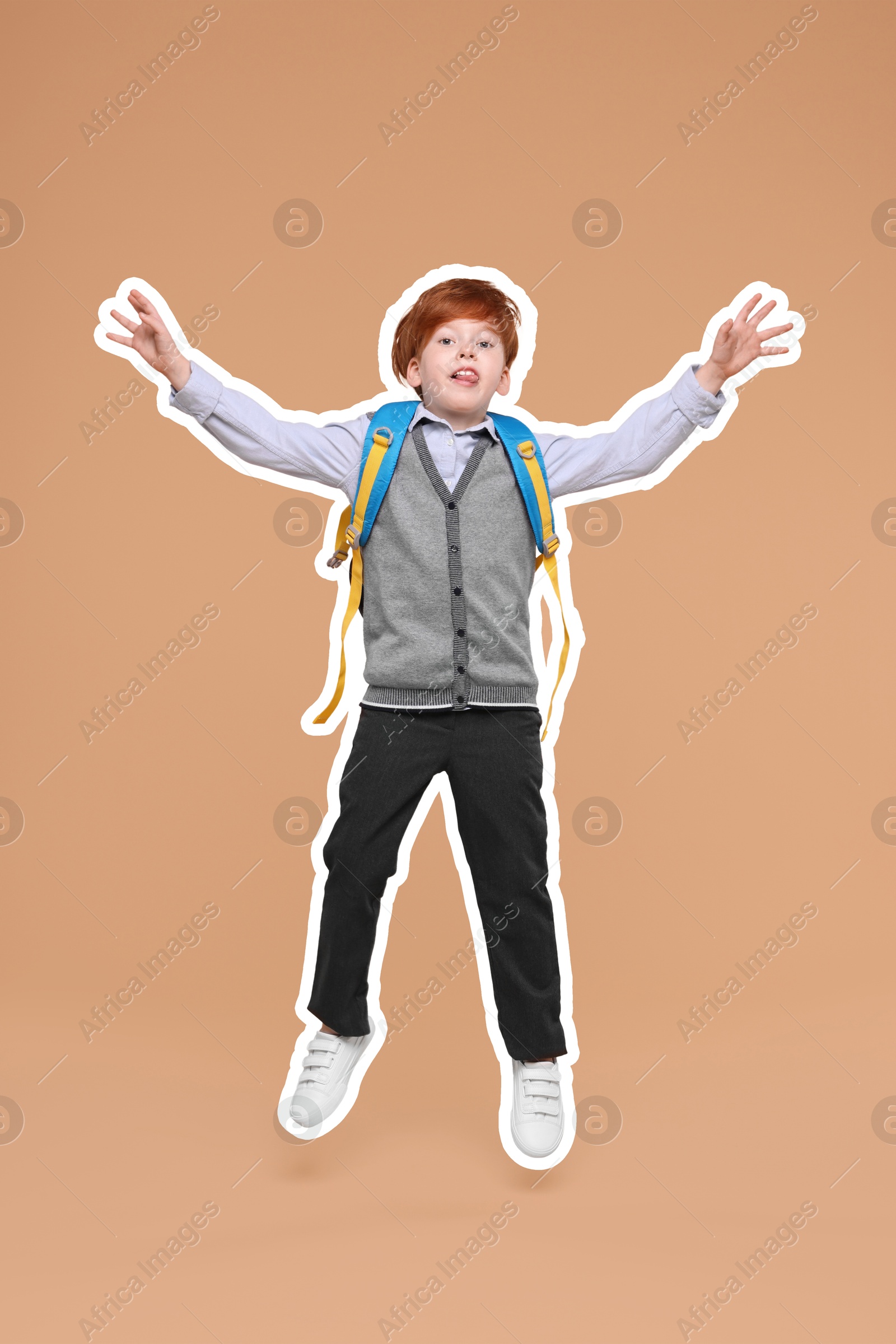 Image of Funny school child with backpack jumping on dark beige background