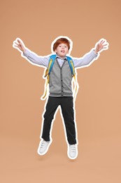 Funny school child with backpack jumping on dark beige background