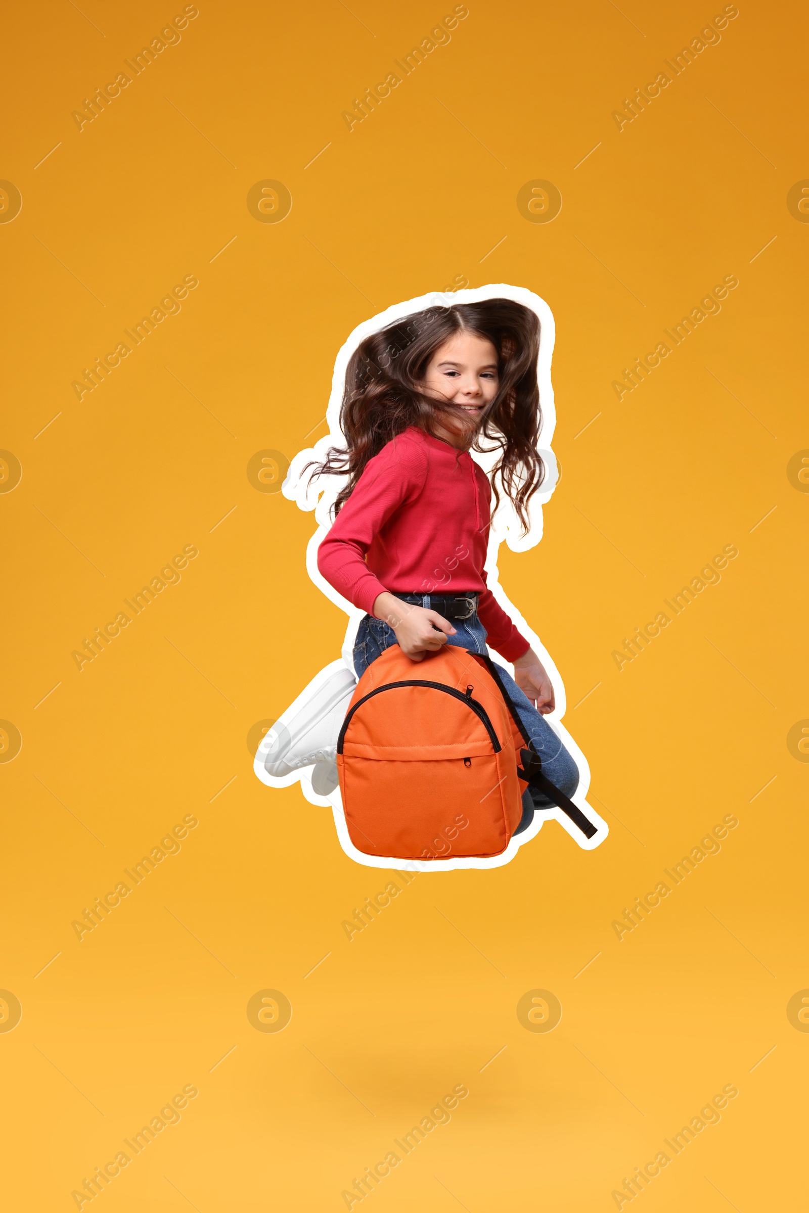 Image of Cute school child with backpack jumping on orange background