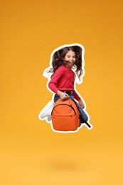 Cute school child with backpack jumping on orange background