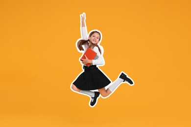 Happy school child with books jumping on orange background