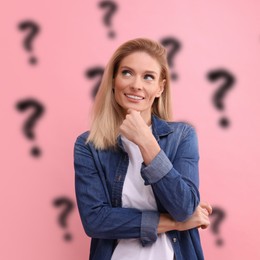 Image of Smiling woman thinking about something on pink background. Question marks behind her