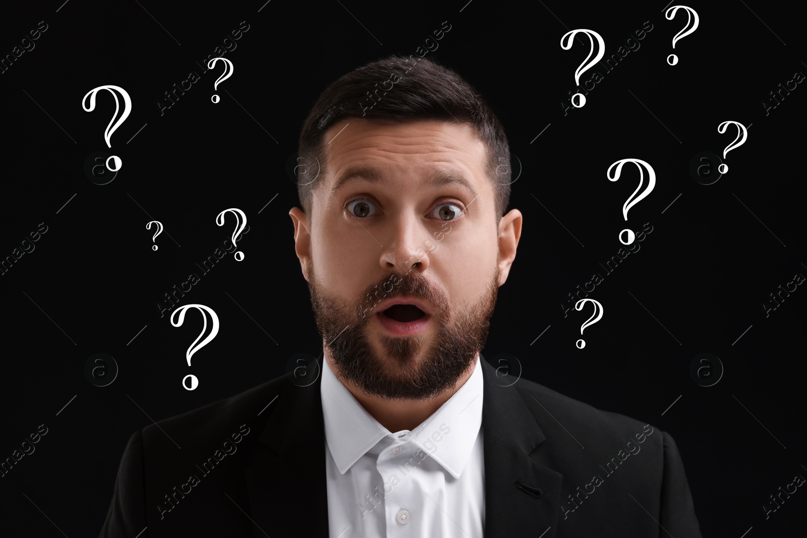 Image of Shocked man and question marks on black background