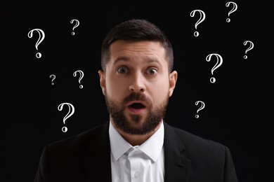 Shocked man and question marks on black background