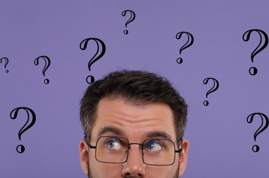 Man and question marks on violet background, closeup