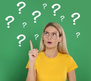 Image of Woman making something up on green background. Question marks around her