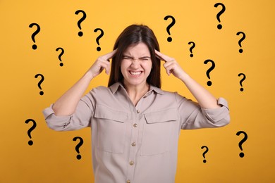 Image of Amnesia. Worried woman and question marks around her on orange background