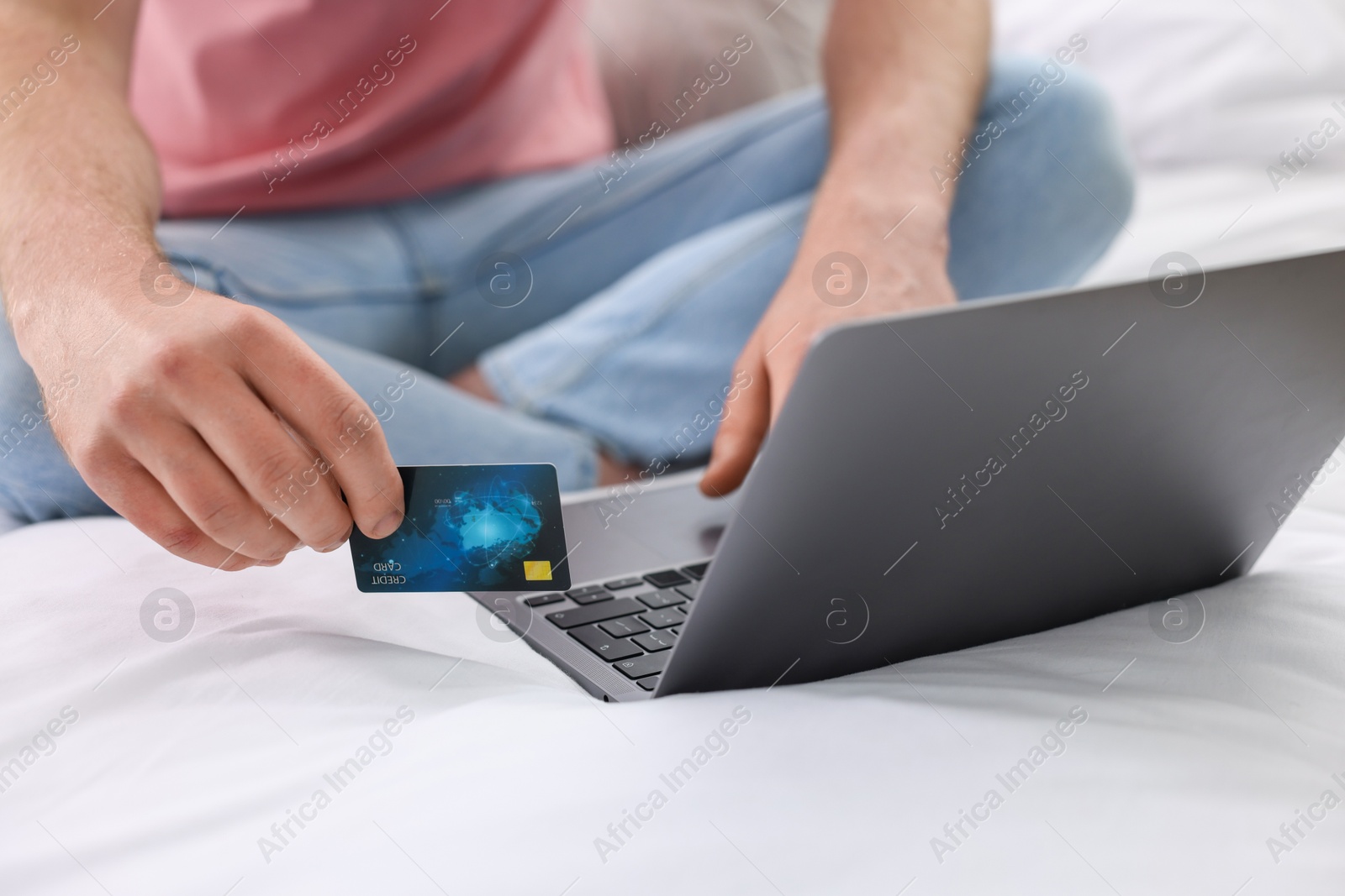 Photo of Online banking. Man with credit card and laptop paying purchase at home, closeup