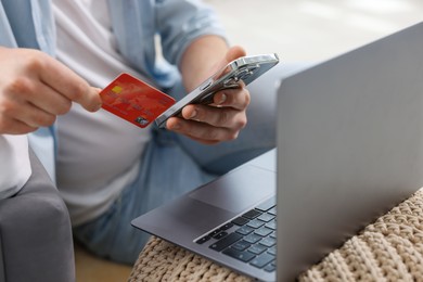 Photo of Online banking. Man with credit card and laptop paying purchase at home, closeup