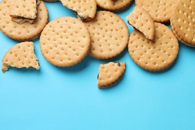 Tasty sandwich cookies on light blue background, top view. Space for text