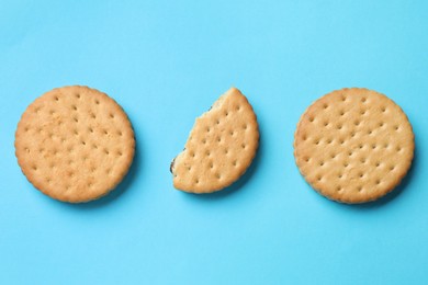 Tasty sandwich cookies on light blue background, top view