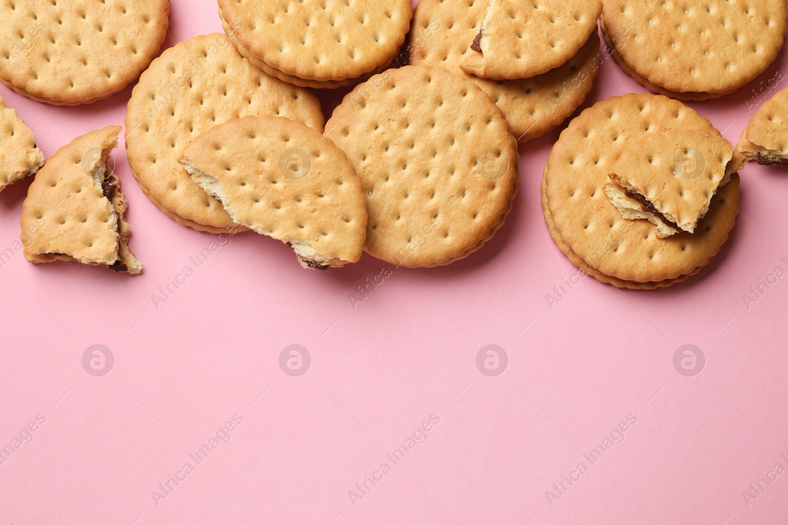 Photo of Tasty sandwich cookies on pink background, top view. Space for text