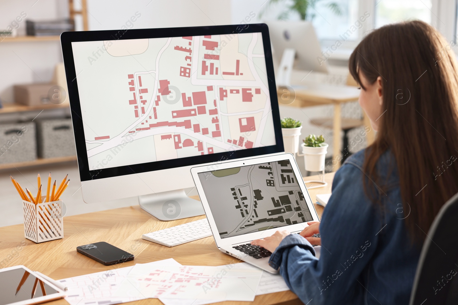 Photo of Cartographer working with cadastral maps at table in office