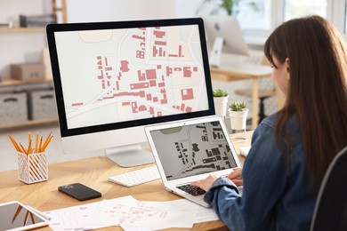 Photo of Cartographer working with cadastral maps at table in office