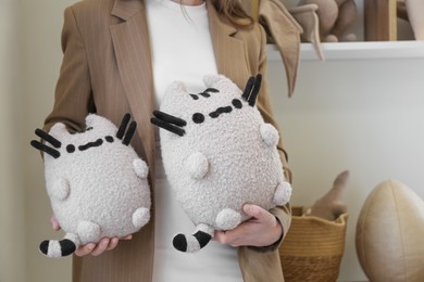 Photo of Woman with cute handmade cats in workshop, closeup