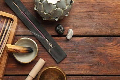 Flat lay composition with incense sticks on wooden table, space for text. Om ligature