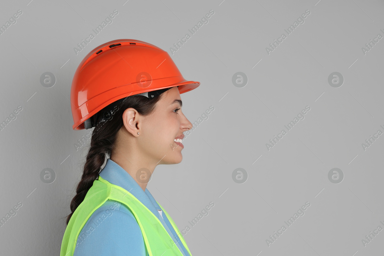 Photo of Engineer in hard hat on grey background, space for text