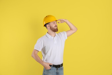 Photo of Engineer in hard hat on yellow background