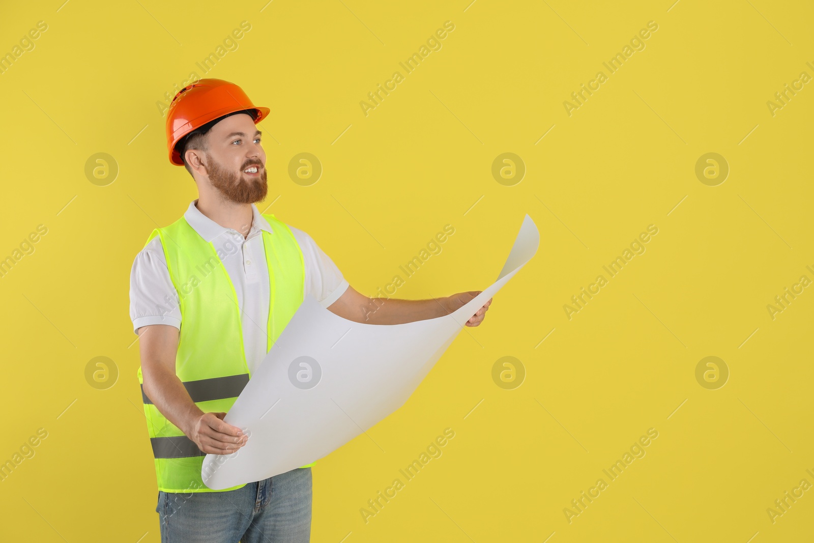 Photo of Engineer in hard hat with draft on yellow background, space for text