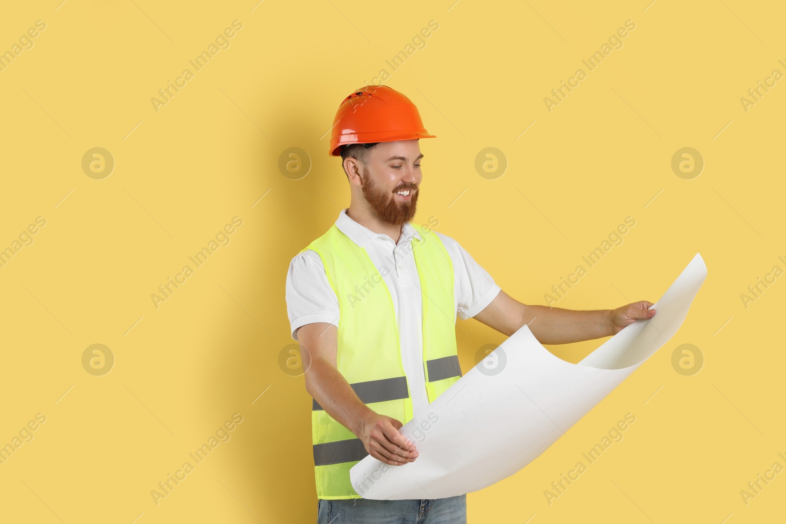 Photo of Engineer in hard hat with draft on yellow background, space for text