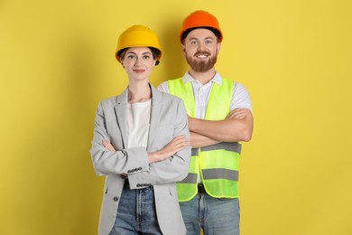 Engineers in hard hats on yellow background