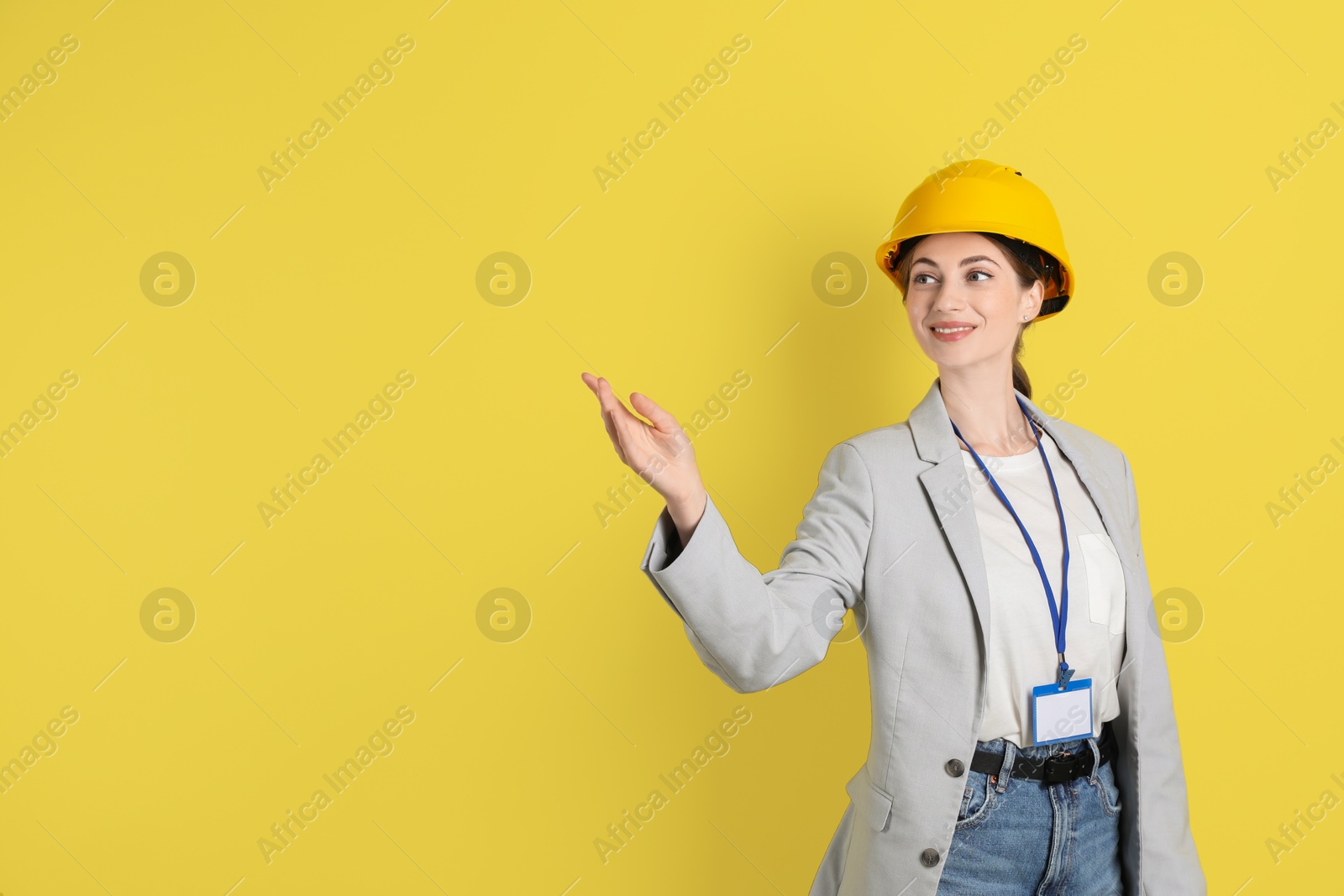 Photo of Engineer in hard hat on yellow background, space for text