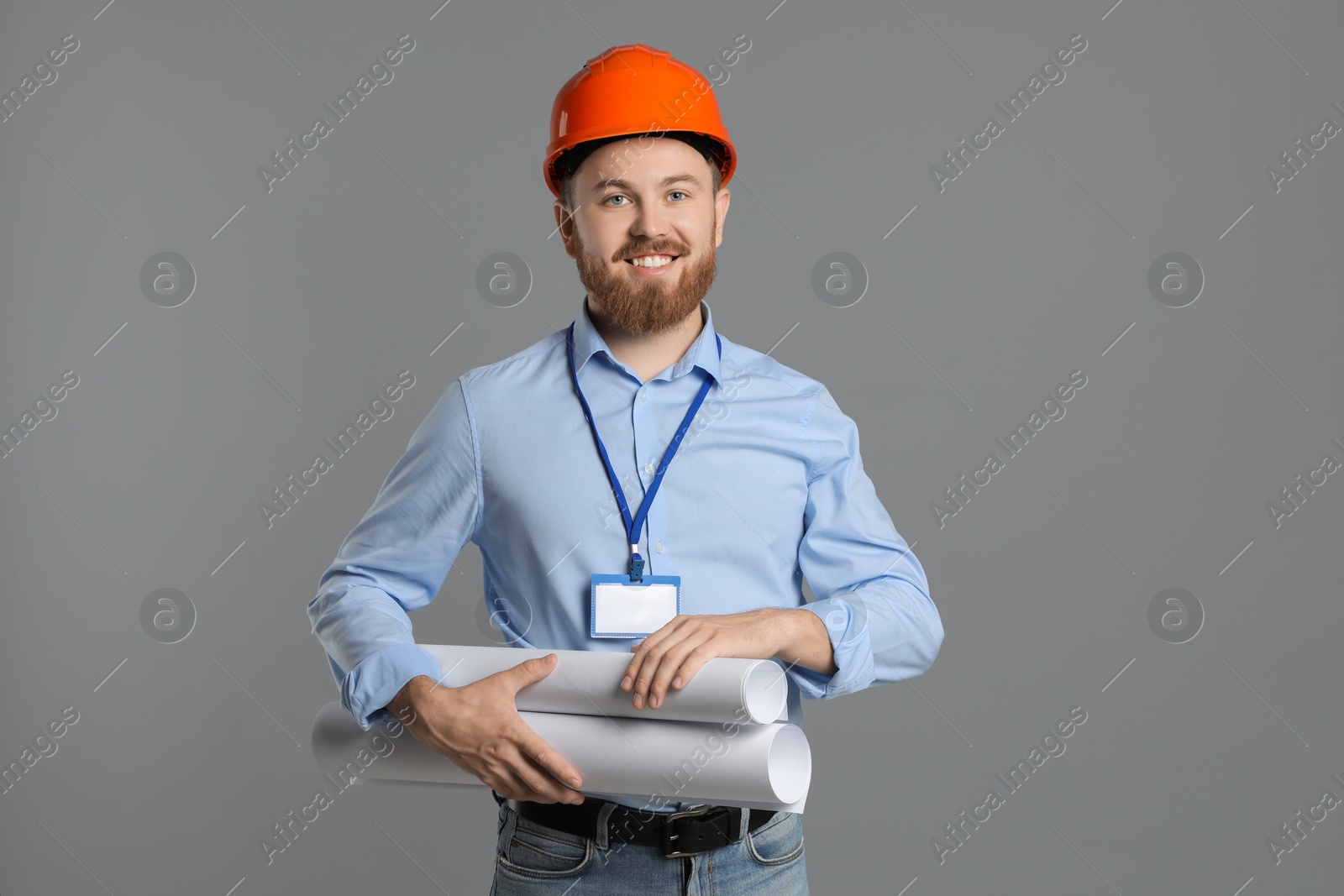 Photo of Engineer in hard hat with drafts on grey background