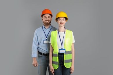 Engineers in hard hats on grey background