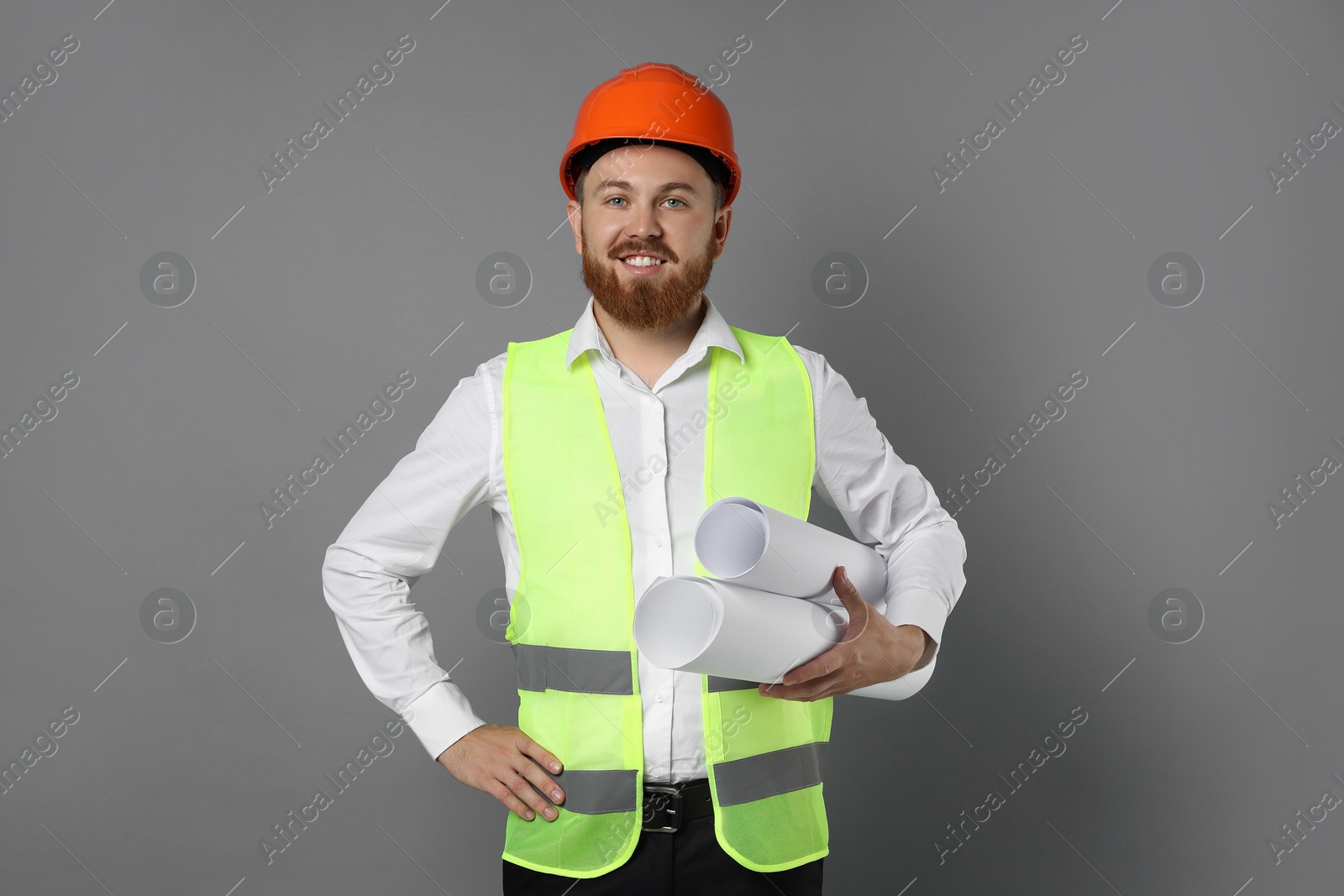 Photo of Engineer in hard hat with drafts on grey background