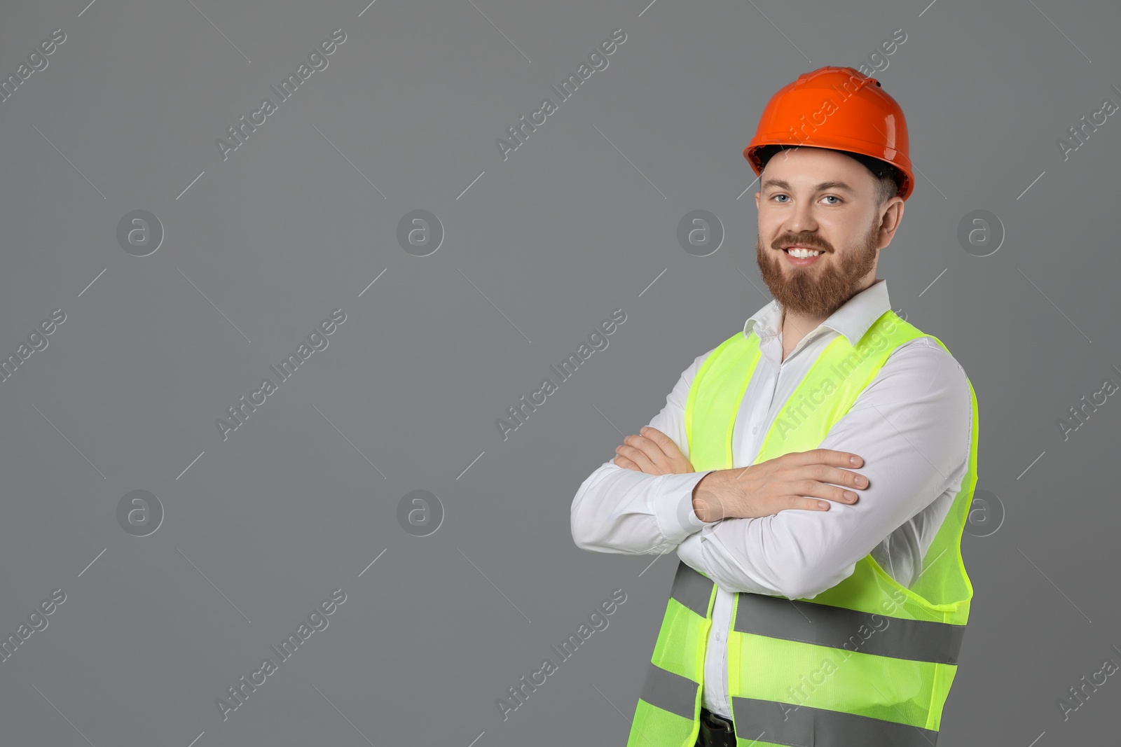 Photo of Engineer in hard hat on grey background, space for text