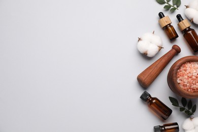 Photo of Different cosmetic products, leaves and cotton flowers on light grey background, flat lay. Space for text