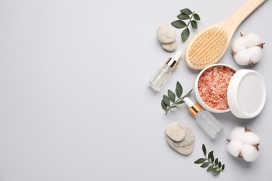 Photo of Different cosmetic products, leaves and cotton flowers on light grey background, flat lay. Space for text