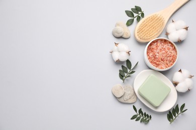 Photo of Different cosmetic products, leaves and cotton flowers on light grey background, flat lay. Space for text