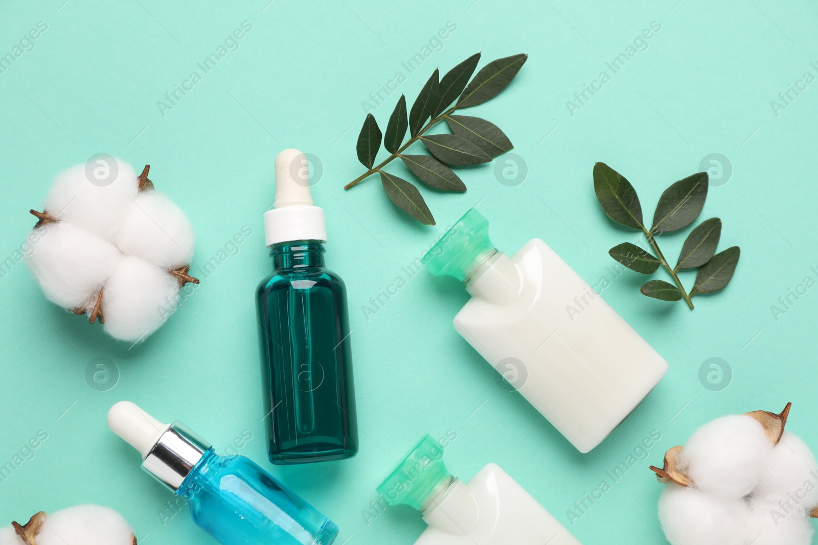 Photo of Different cosmetic products, cotton flowers and leaves on turquoise background, flat lay