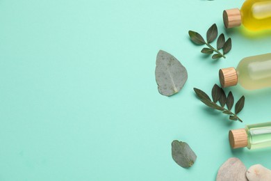 Cosmetic products and green leaves on turquoise background, flat lay. Space for text