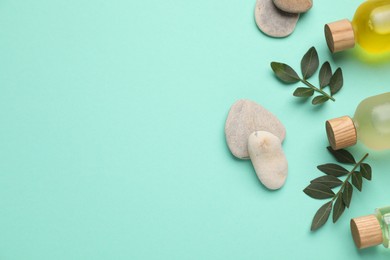 Photo of Cosmetic products and green leaves on turquoise background, flat lay. Space for text