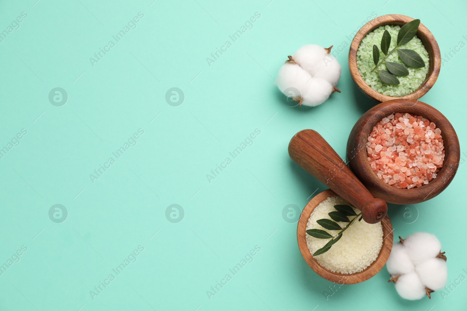 Photo of Different cosmetic products, cotton flowers and green leaves on turquoise background, flat lay. Space for text