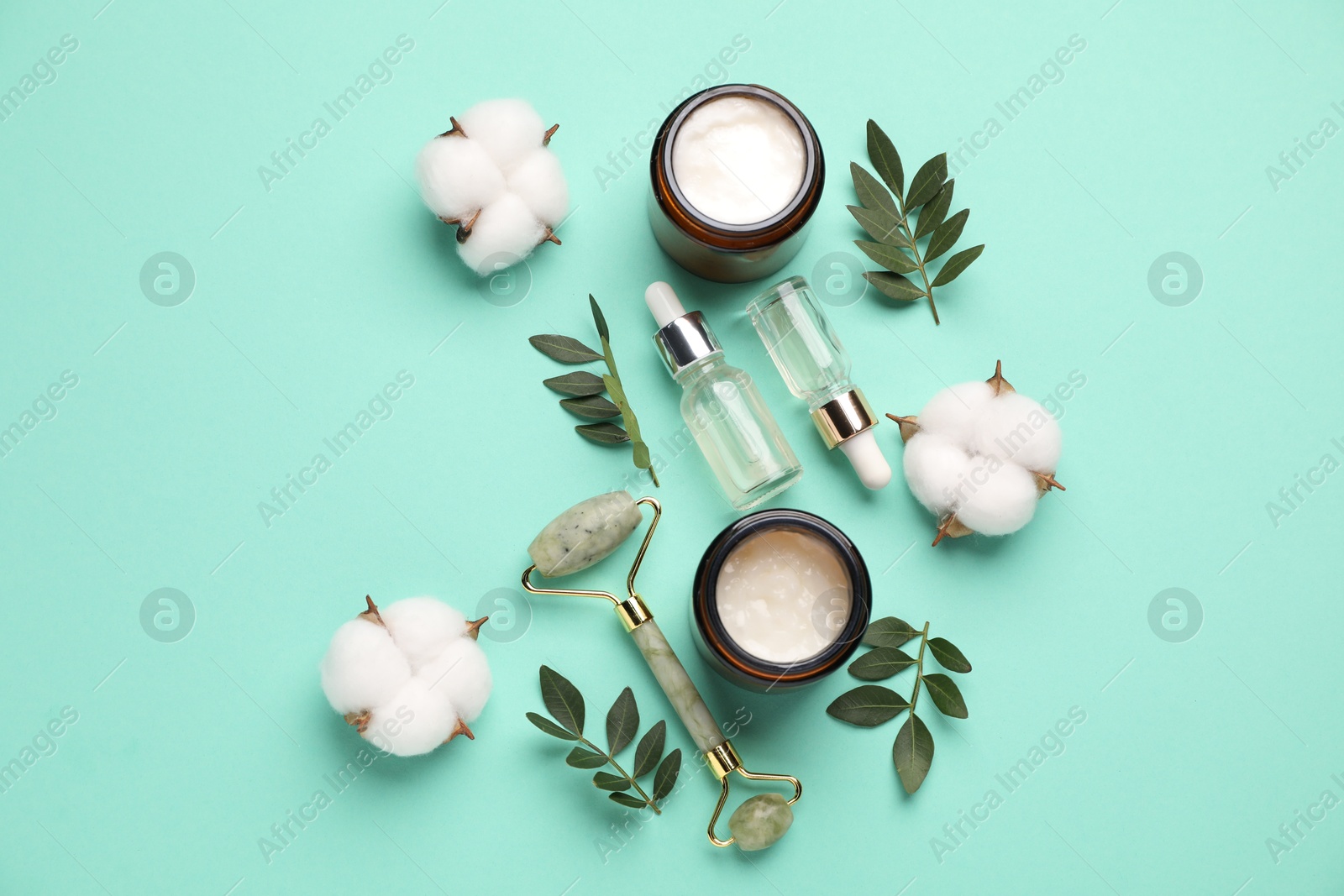 Photo of Different cosmetic products, cotton flowers and leaves on turquoise background, flat lay