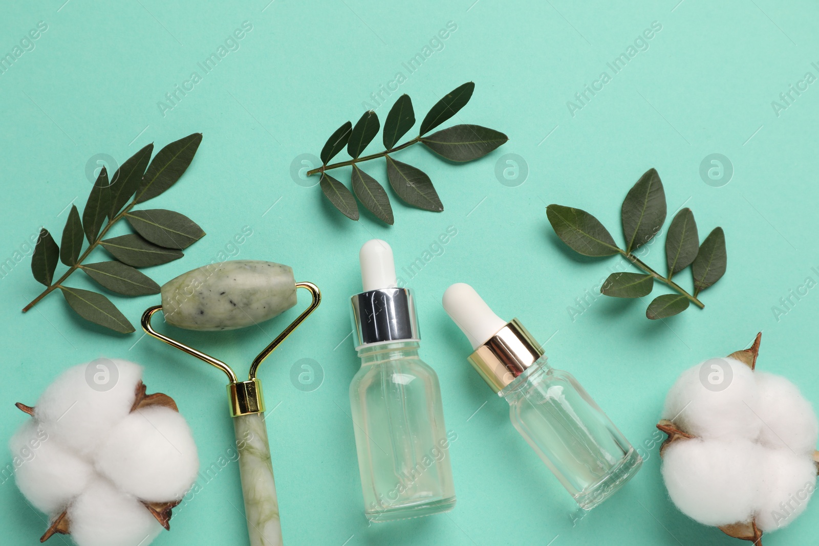 Photo of Different cosmetic products, cotton flowers and green leaves on turquoise background, flat lay